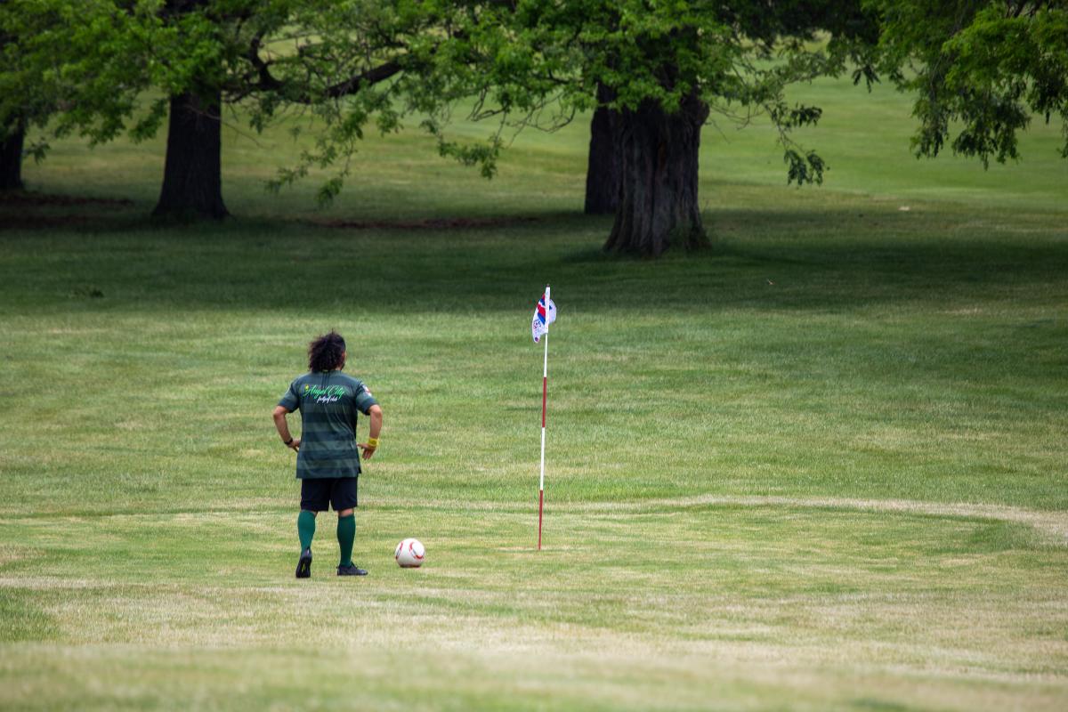 A player watching the Footgolf ball go toward the hole
