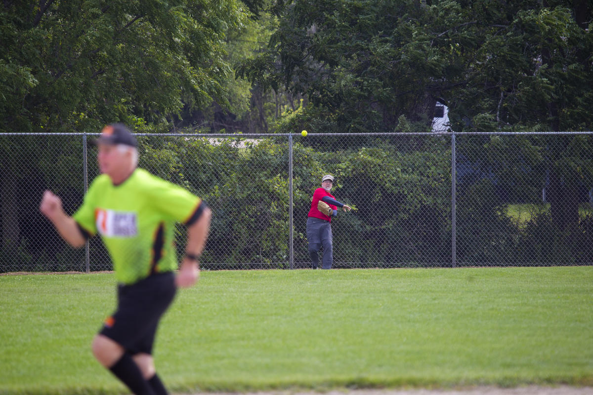 Person throwing the ball while a runner is going by