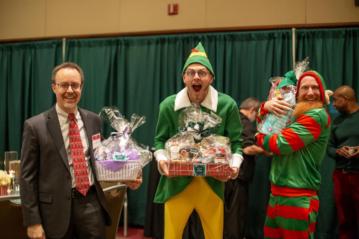 Kellogg Center, Zap Zone XL, and High Caliber employees holding their booth design prizes
