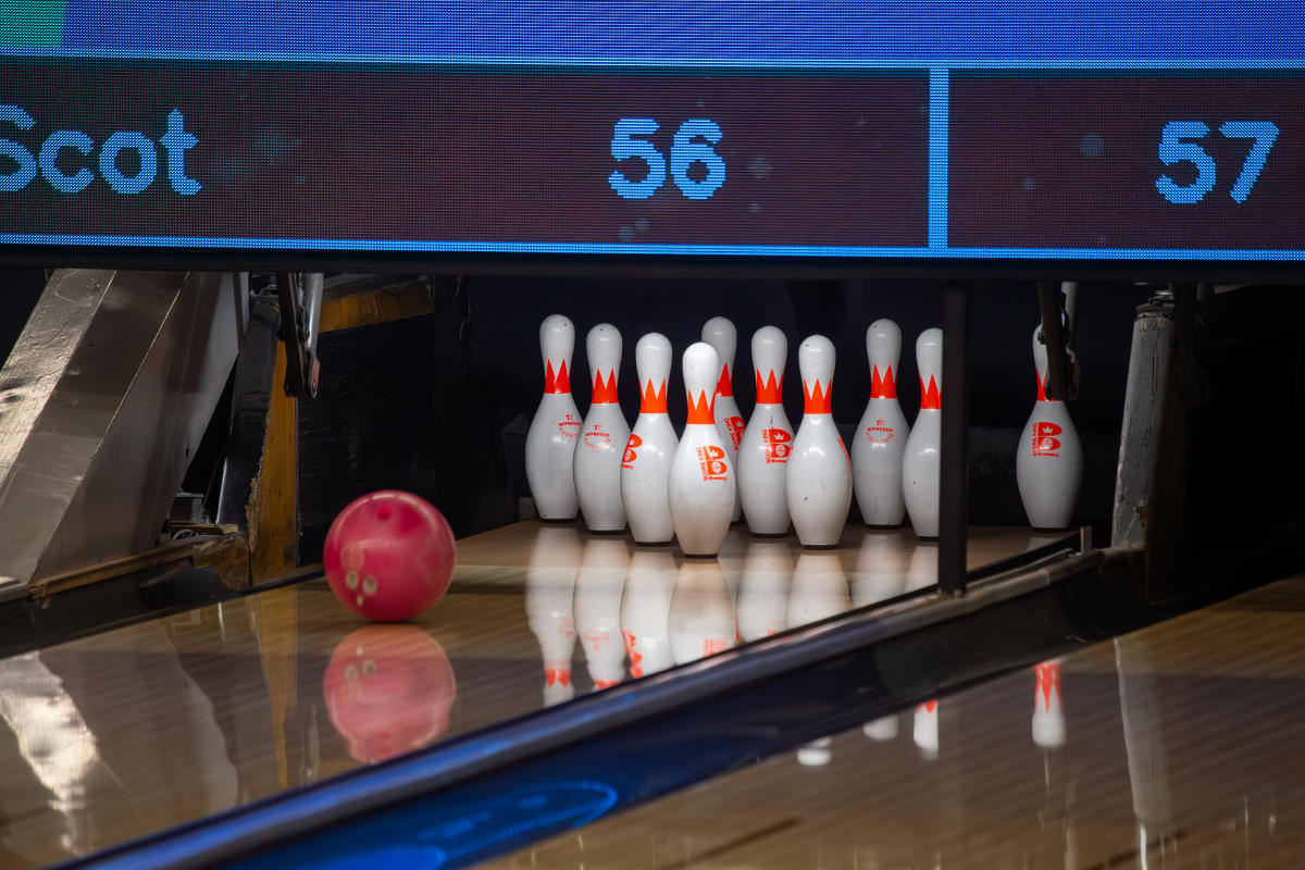 Bowling ball moving down the lane toward pins
