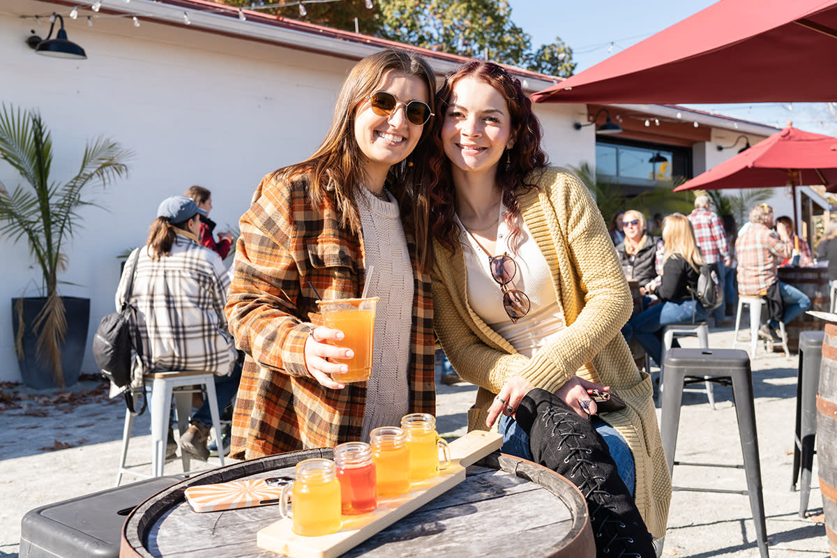 Two ladies outside with glasses of cider