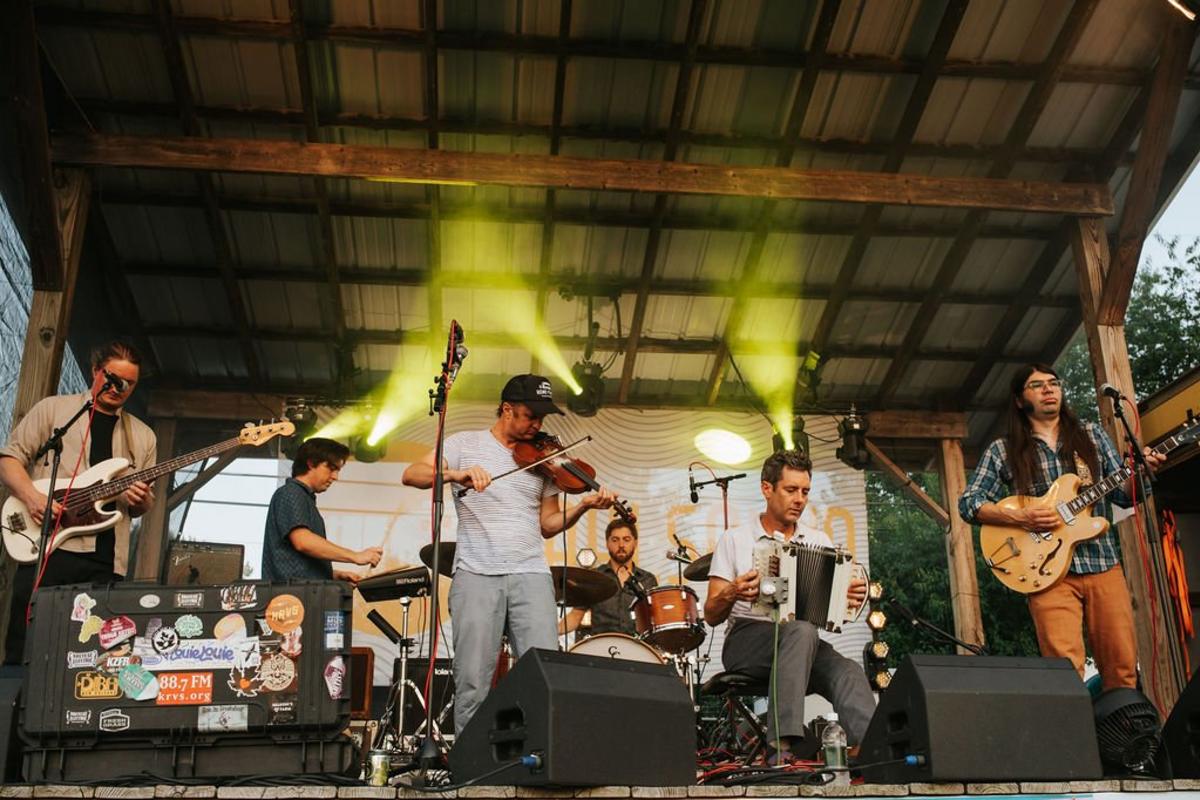 A violinist playing with a band on a stage