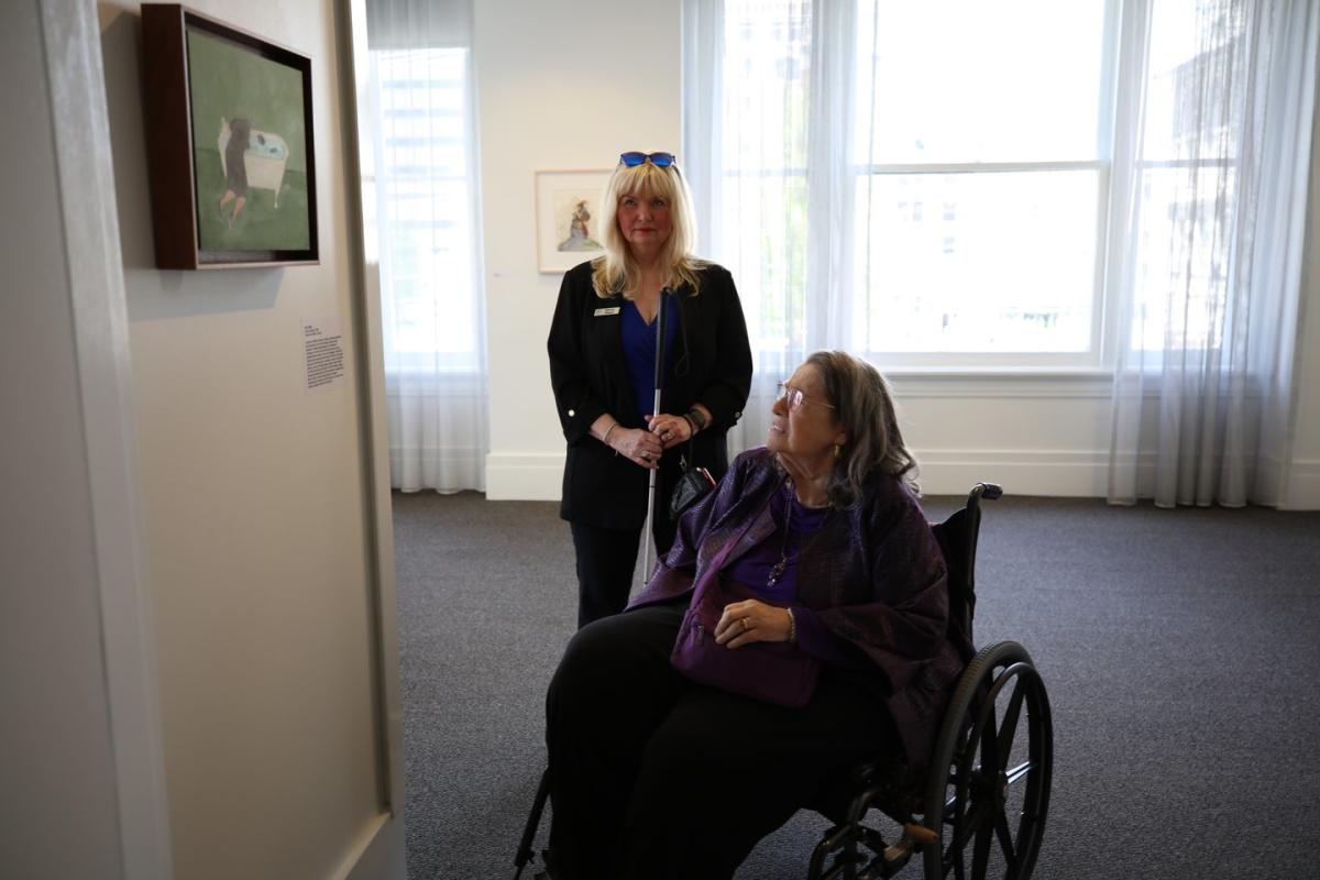 Two women look at art in a gallery