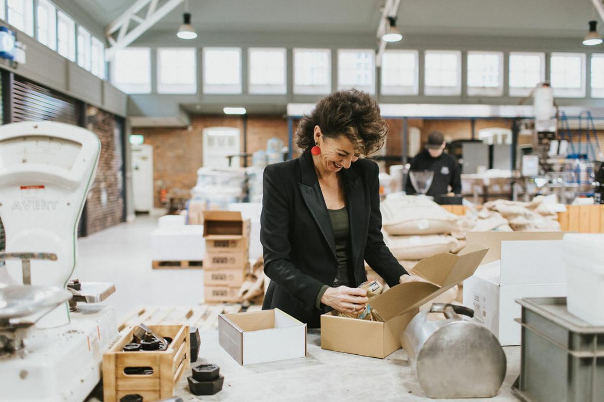 A lady packs a box of coffee within the Stokes coffee roastery