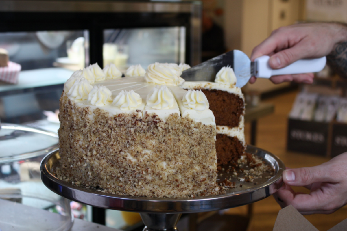 A cake being cut at a cafe