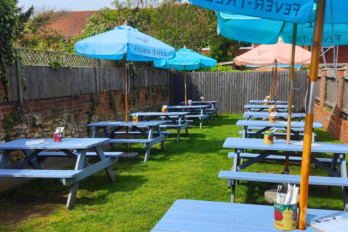 A row of tables set outdoors at Duke Williams beer garden