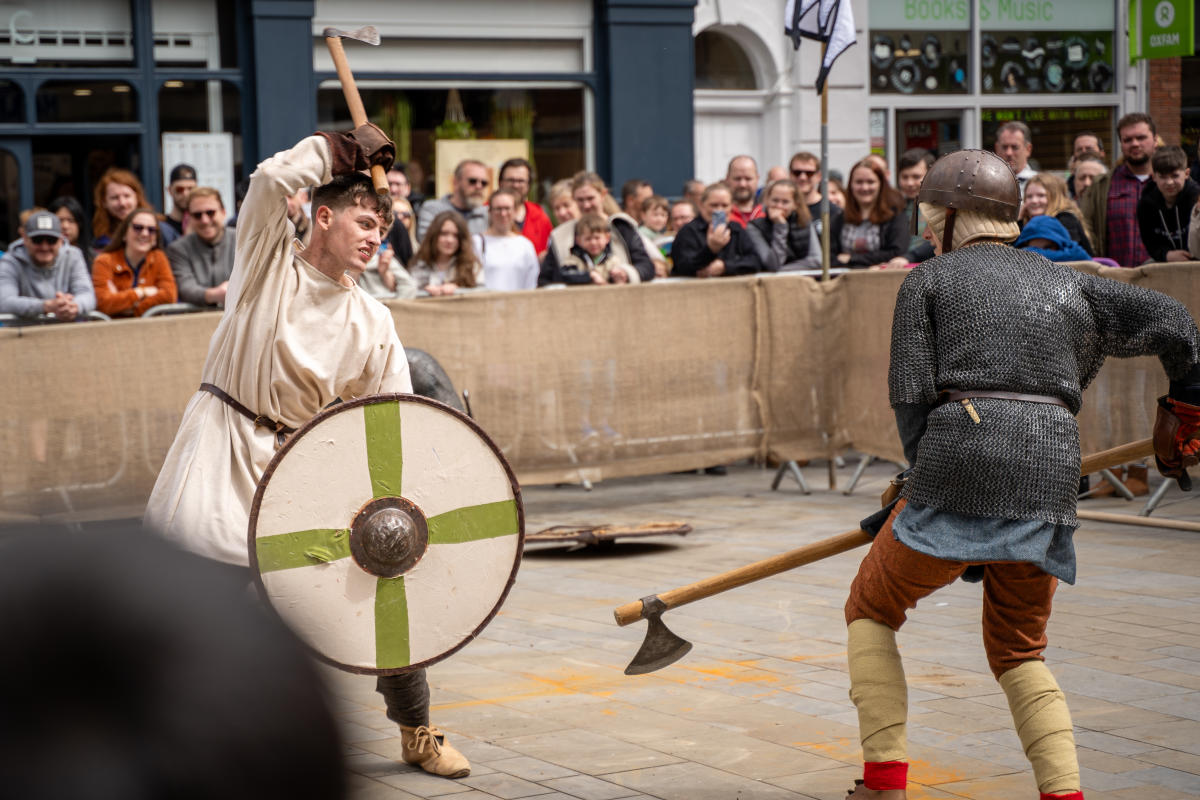Two actors doing a re-enactment of a battle in front of an audience