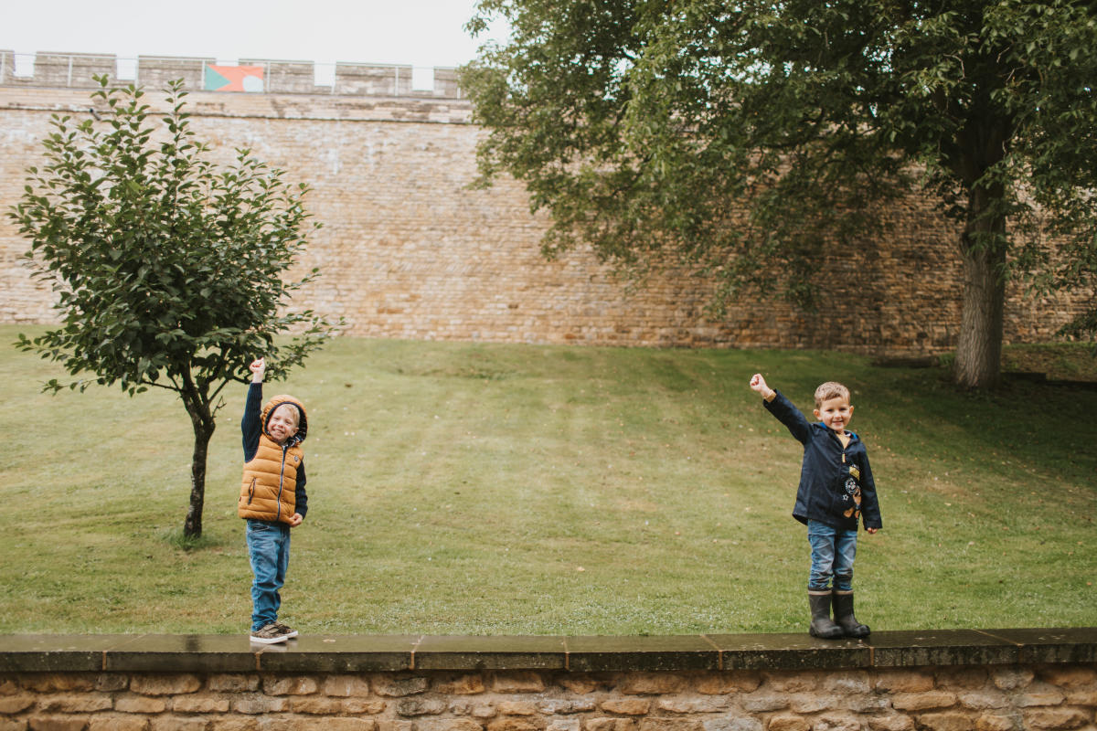 two kids in raincoats standing outside Lincoln Castle