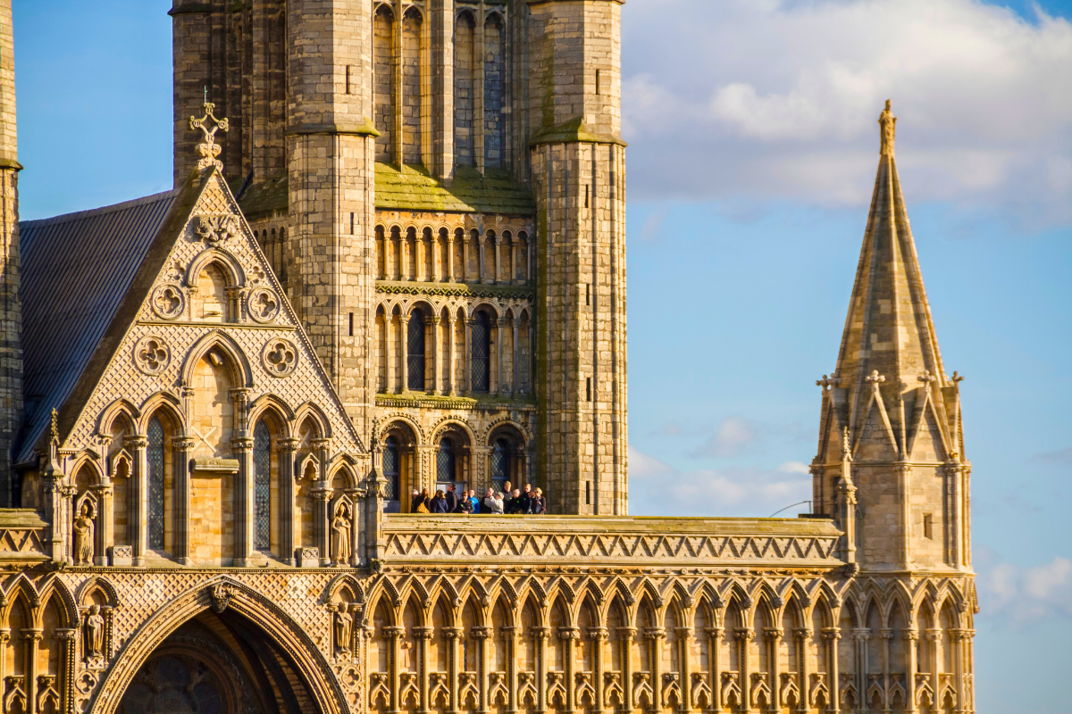 A group of people enjoying a tour, standing on the roof of Lincoln Cathedral