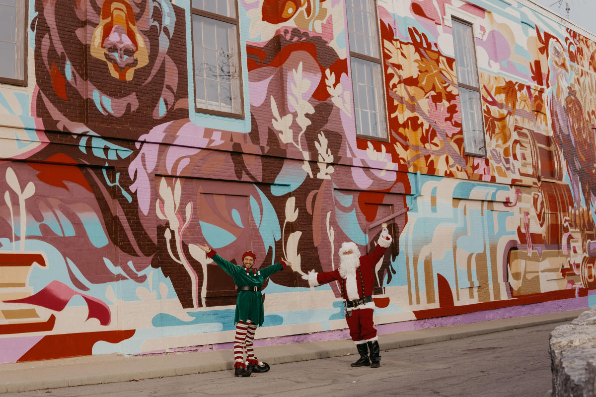 Santa and elf in front of Geneseo mural