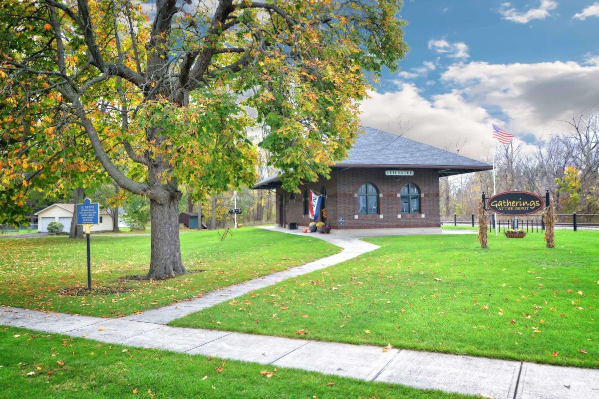 Building along pathway next to lawn and tree