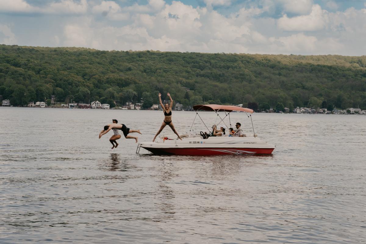 Three People Jumping Into Conesus Lake