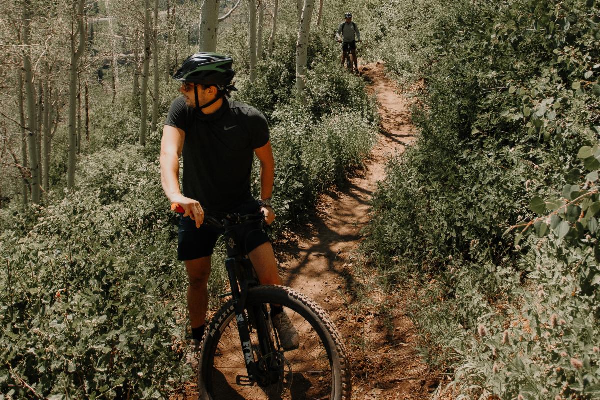 Man Biking Through Forest