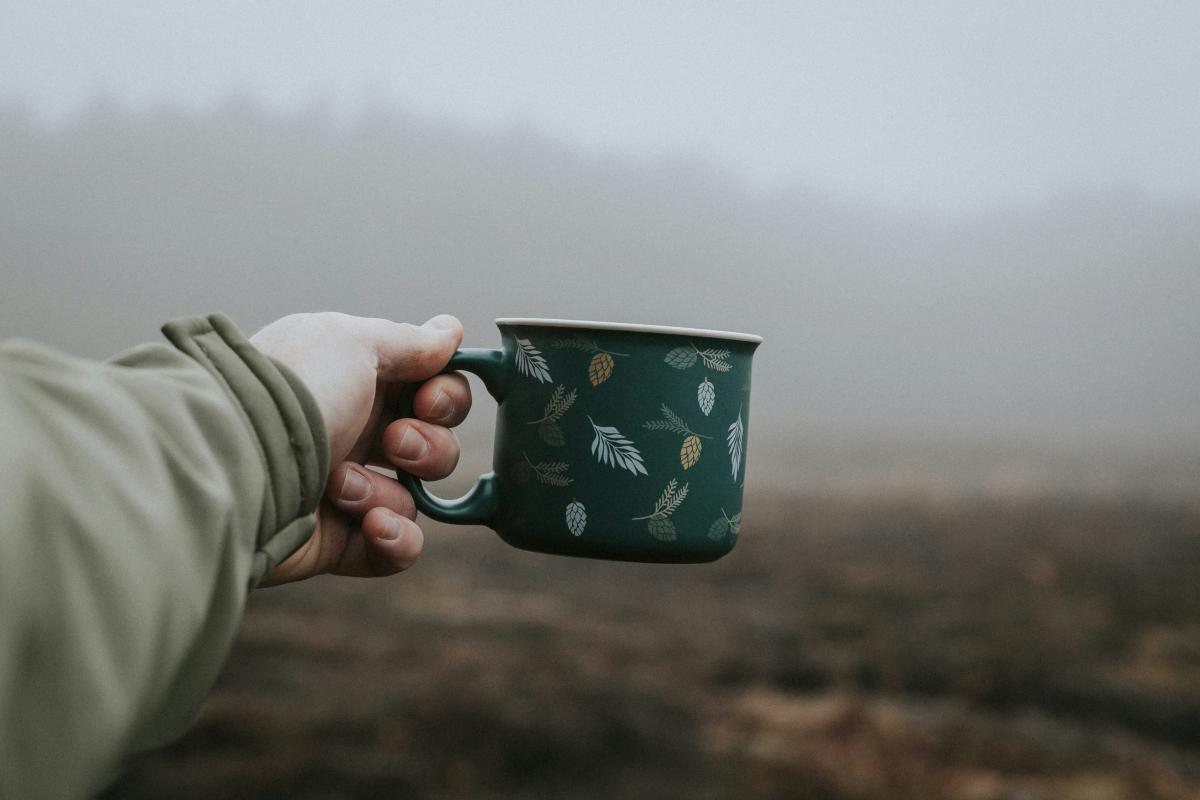 Hand holding mug outside