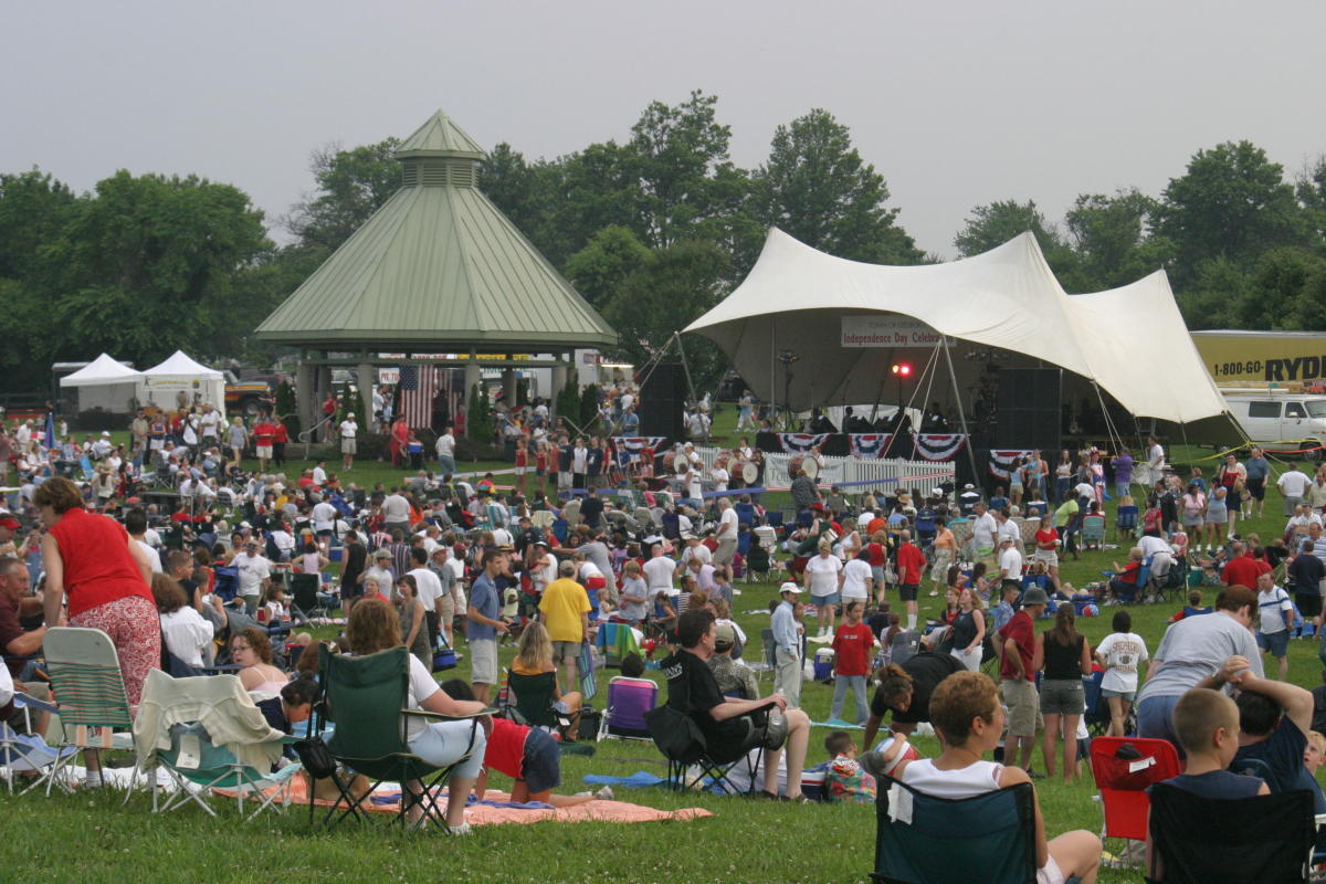 Large crowd gathered on the lawn at the Fourth of July celebration with live music stage at Ida Lee Park in Leesburg, Loudoun County