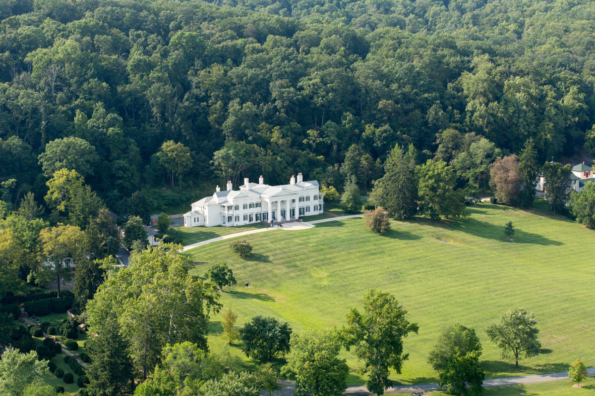 Aerial view of the white Greek Revival mansion at Morven Park set among rolling lawns and woodland in Leesburg, Loudoun County