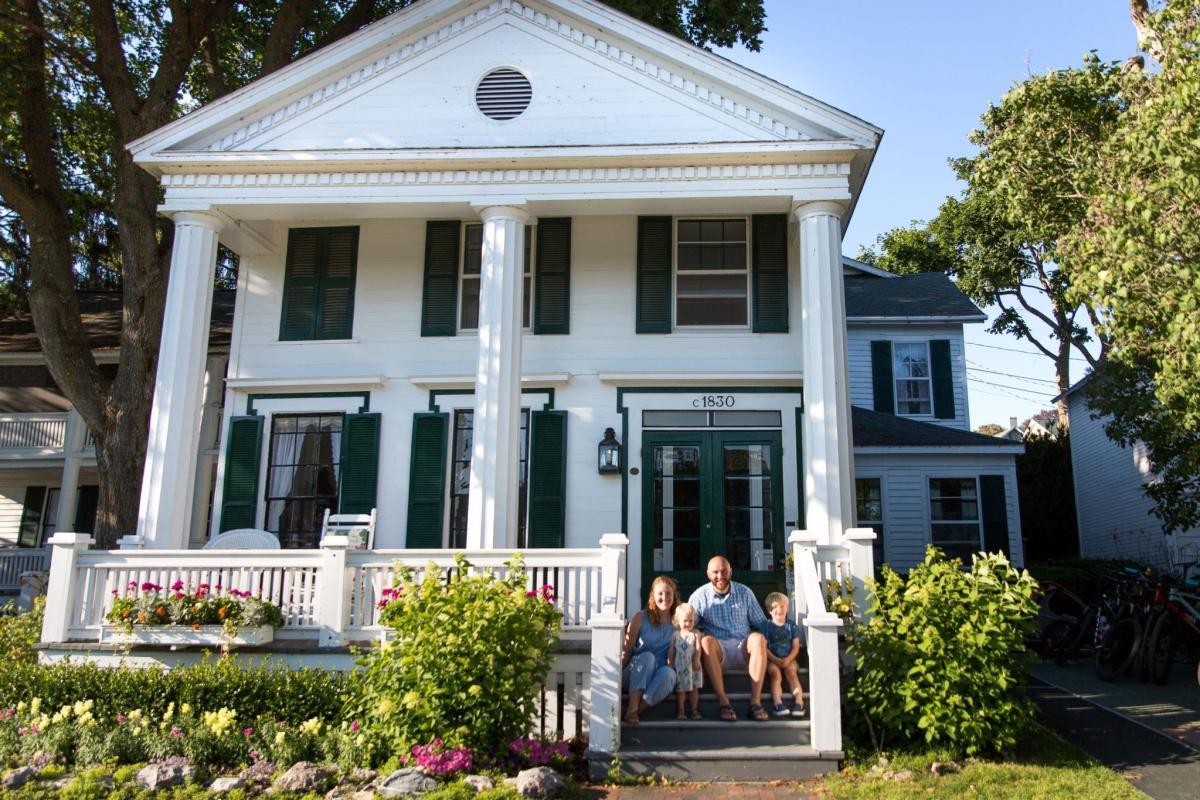 The family that lives in Haan’s 1830 Inn on Mackinac Island sits on the front porch steps of the B&B.