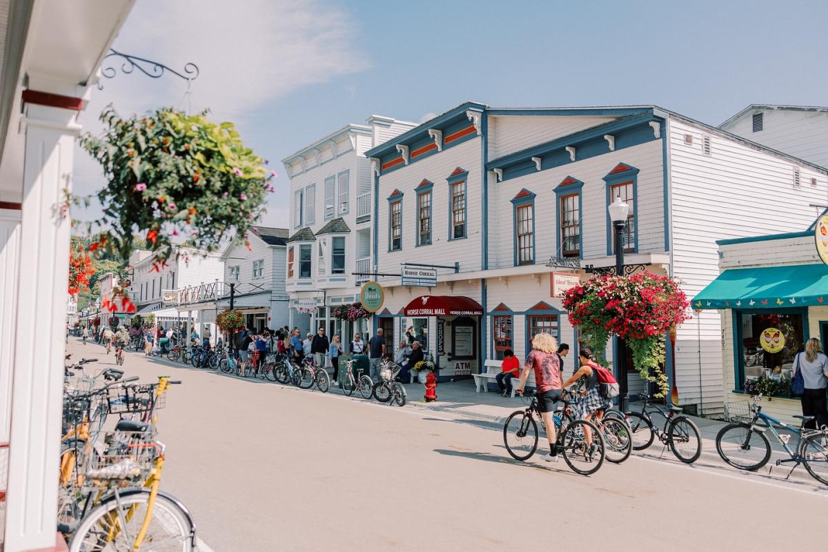Bicycles line the road on Mackinac Island’s Main Street as people walk along the sidewalk.