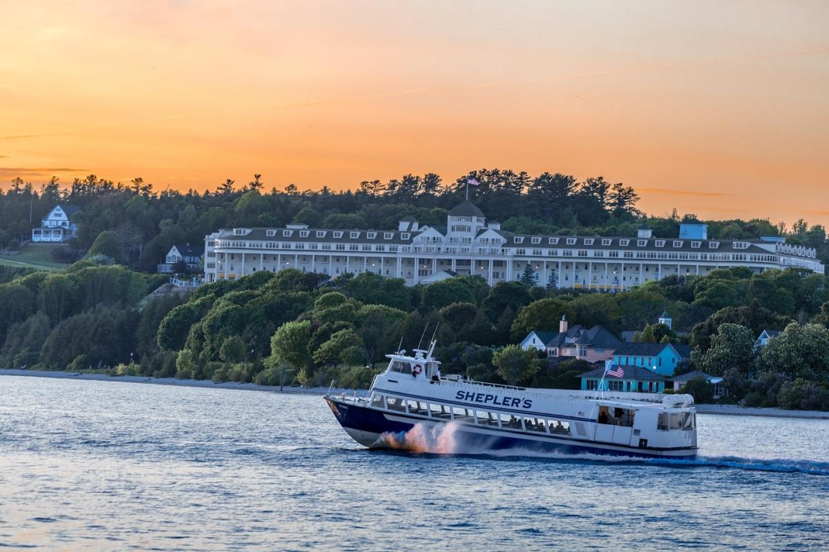 A Shepler’s Mackinac Island Ferry boat passes through the water in front of Grand Hotel