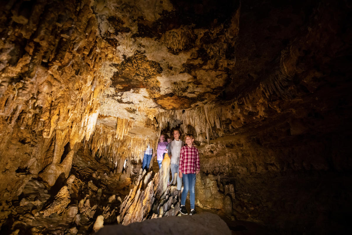 A group of children walk through Cave of the Mounds