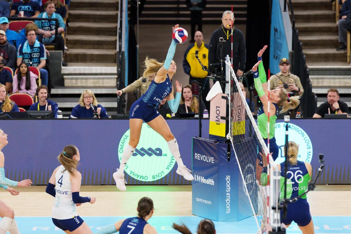 Woman athlete spiking volleyball at a LOVB Madison Volleyball game at Alliant Energy Center