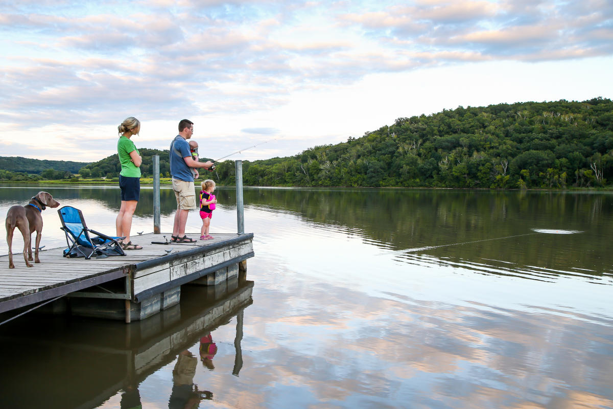 A family fishes off a pier at Indian Lake County Park