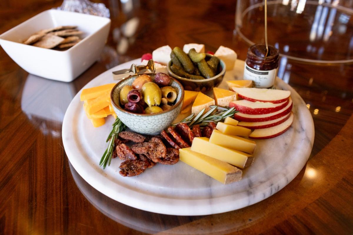 A cheese plate artfully arranged with local cheeses, fruit, and olives