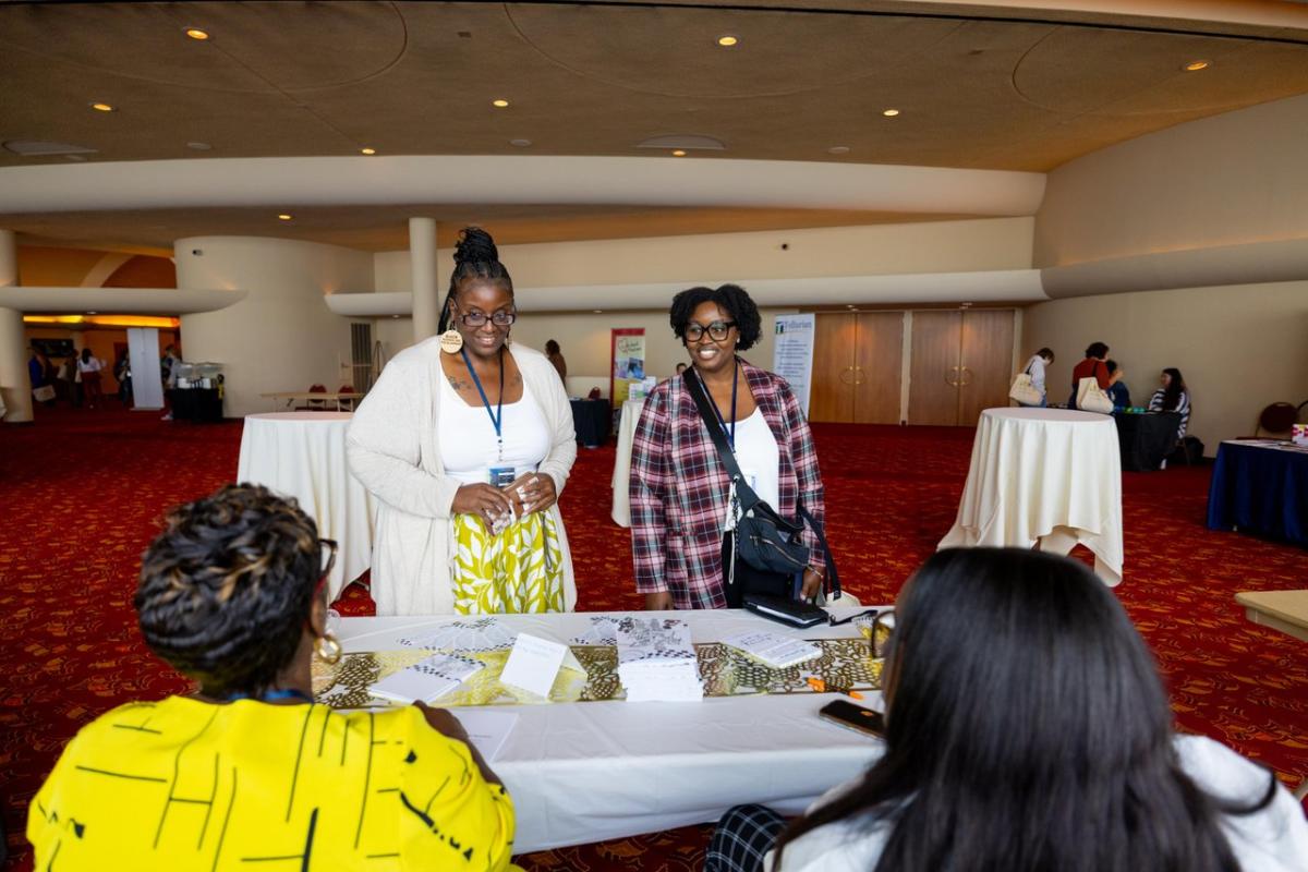 Two conference attendees at Monona Terrace standing in front of a registration desk