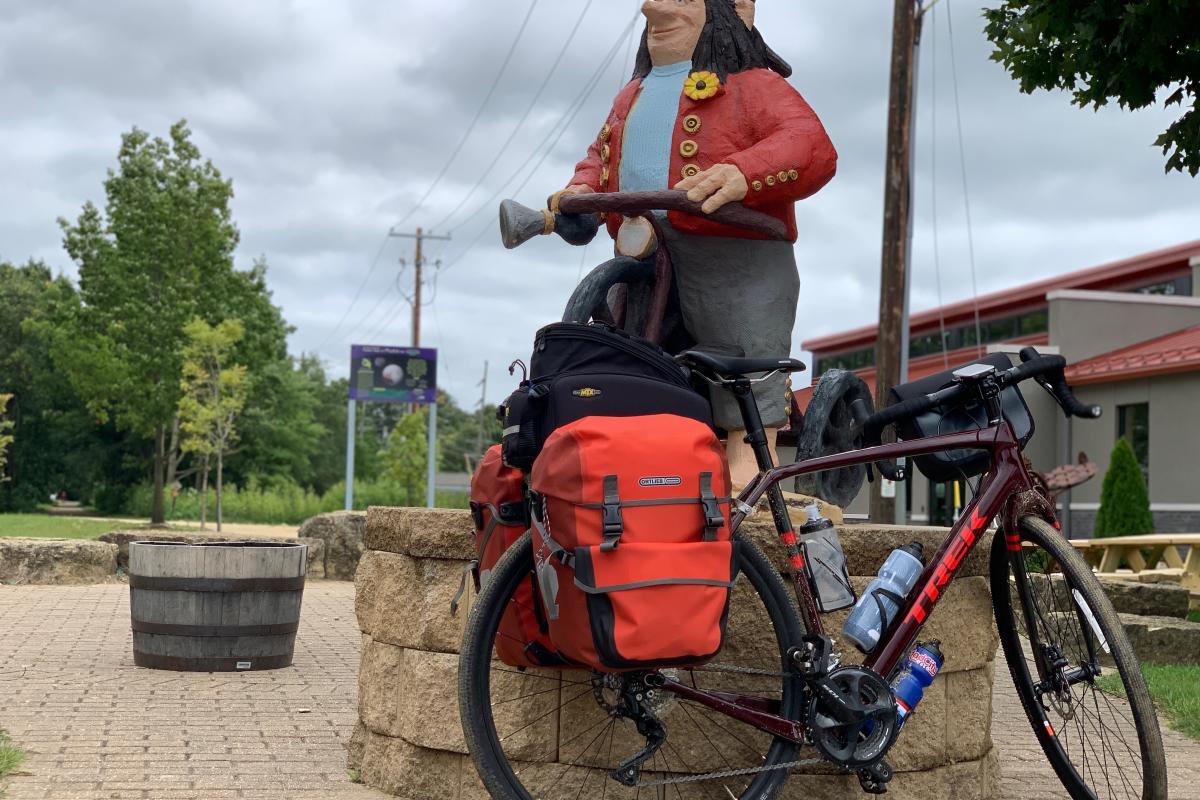 A bicycle stands parked next to a statue in Mt. Horeb, WI