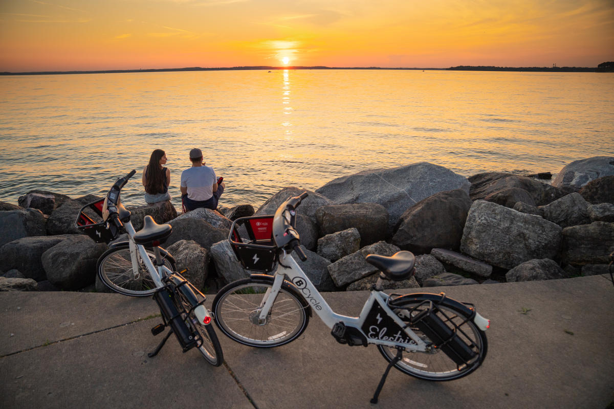 A couple takes a break from biking to watch a sunset