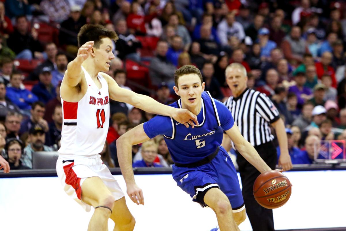 Two athletes competing in the WIAA Boys Basketball Tournament