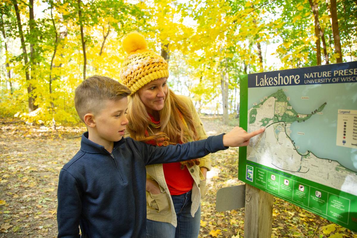 A mother and son view the Lakeshore Nature Preserve trail map