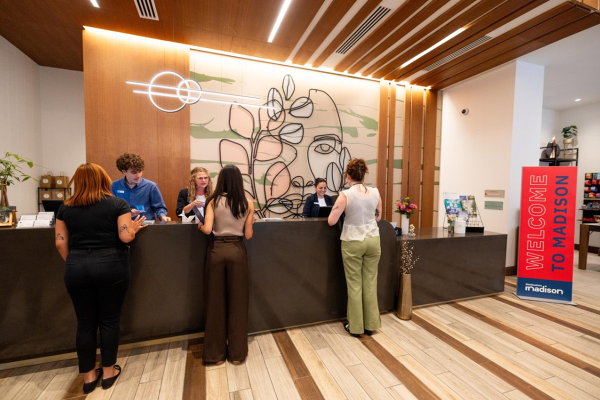 Three people checking in at the Embassy Suites Hotel front desk in Madison, WI
