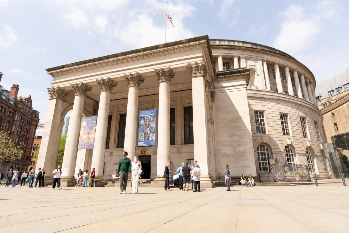 People walking through St Peter's Square in Manchester