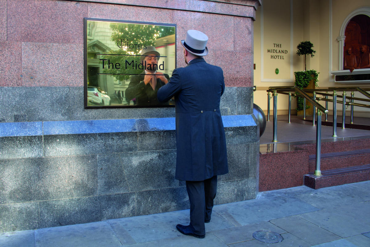 Doorman at Manchester's Midland hotel straightening his tie.