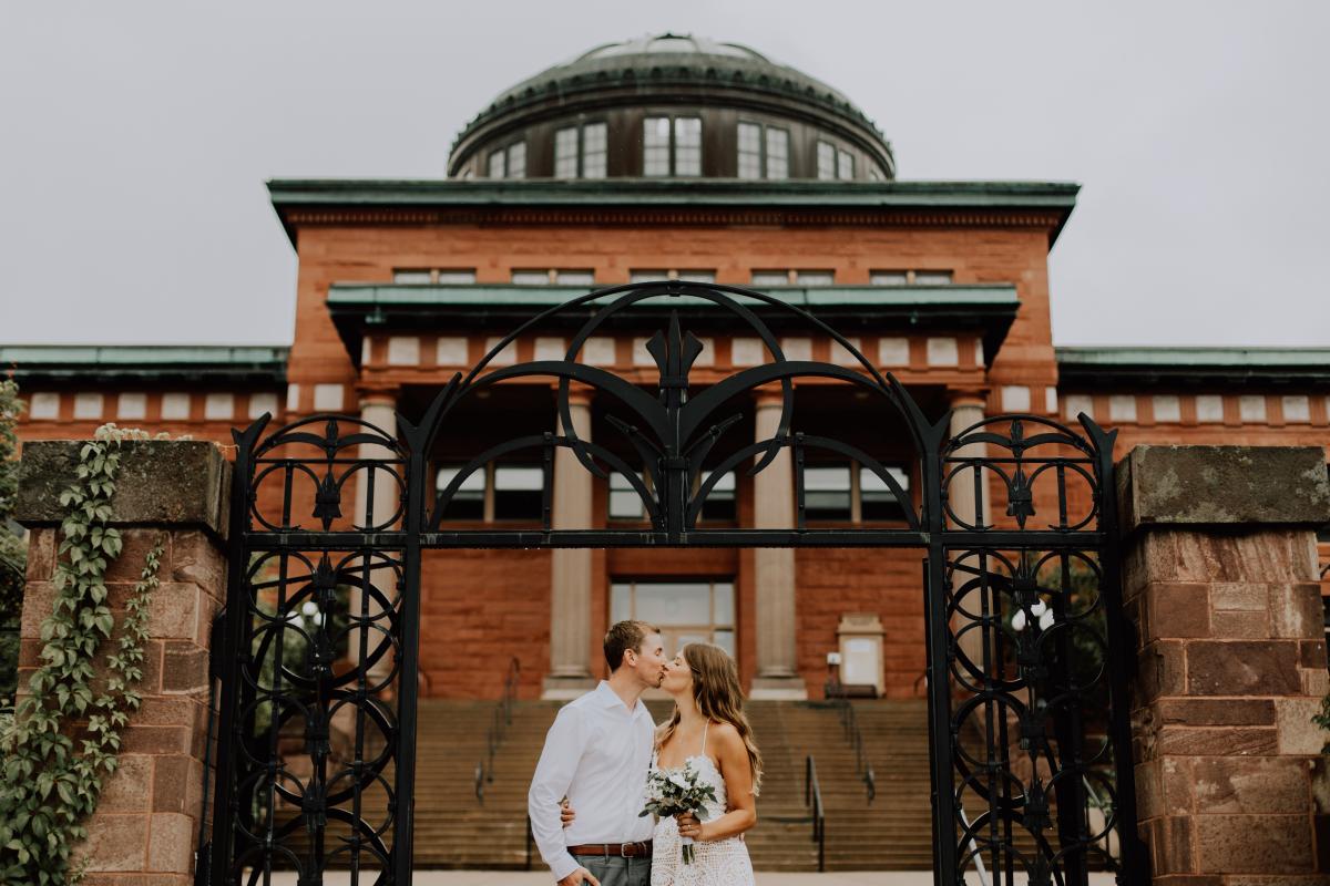 A newlywed couple shares a kiss outside of the Marquette Courthouse where they eloped.