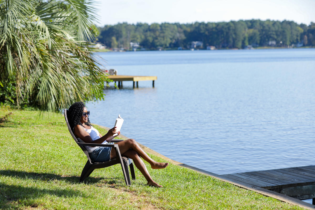 Lady reading by lake