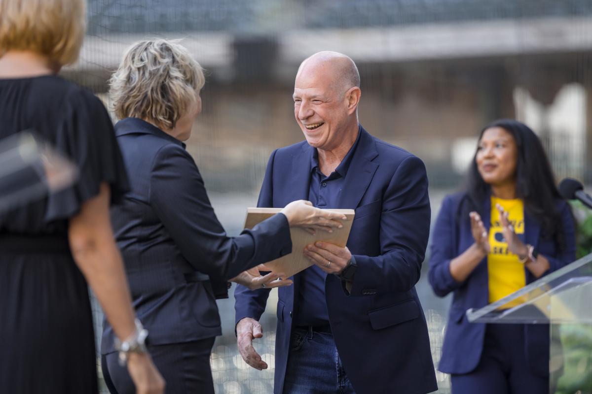 Man in navy suit accepts award on stage