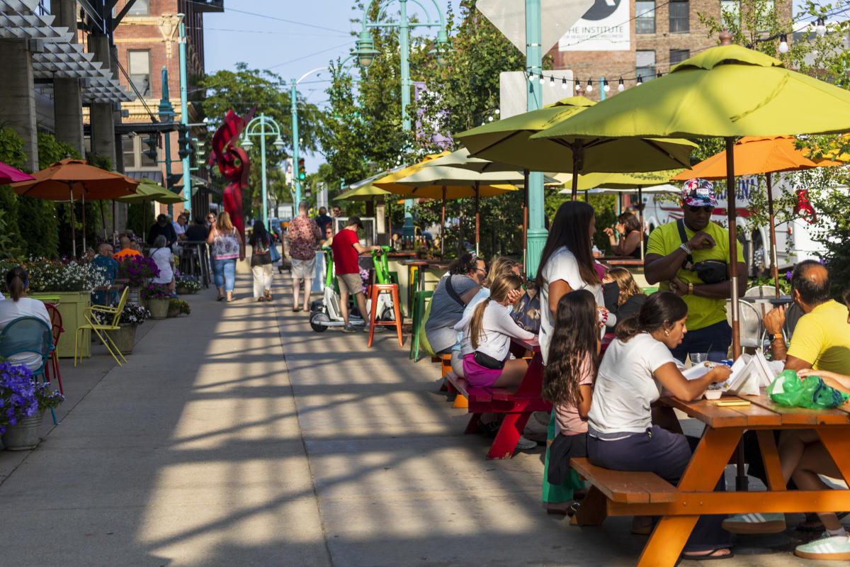 Groups sit on colorful picnic tables outside the Milwaukee Public Market in the Historic Third Ward.