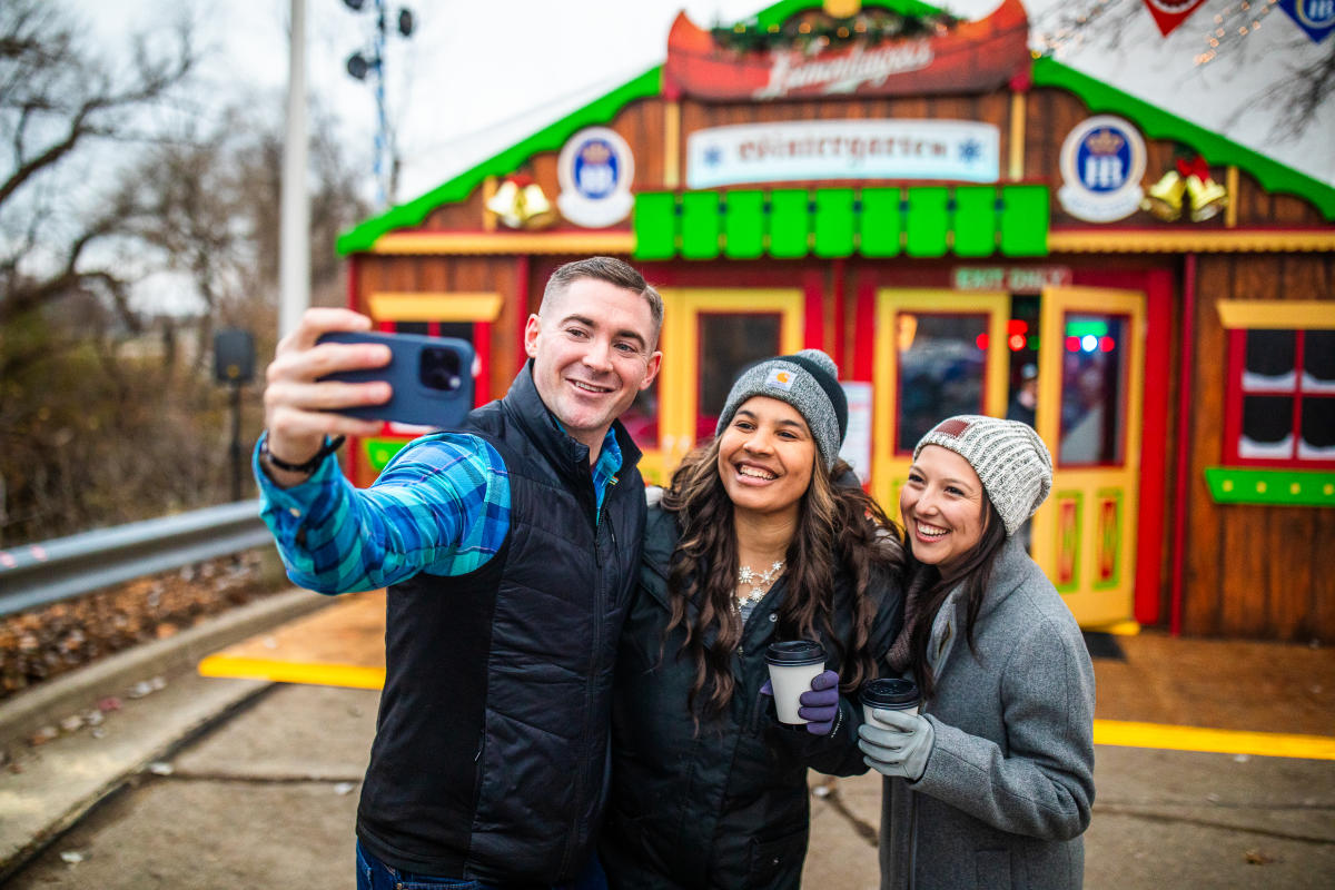 Friends taking selfie in front of the Winter Garden Tent at the Wauwatosa Holiday Market
