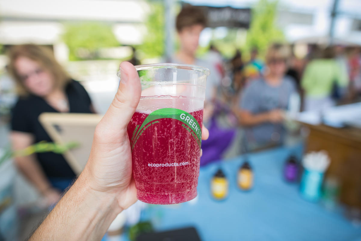 Clear cup of red juice held up at Muskegon Farmers Market
