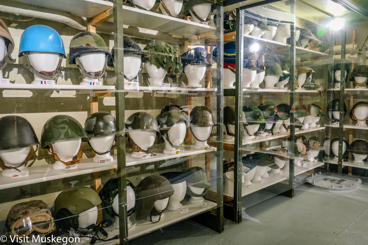Display of military helmets and headgear from around the world at the USS LST 393 museum