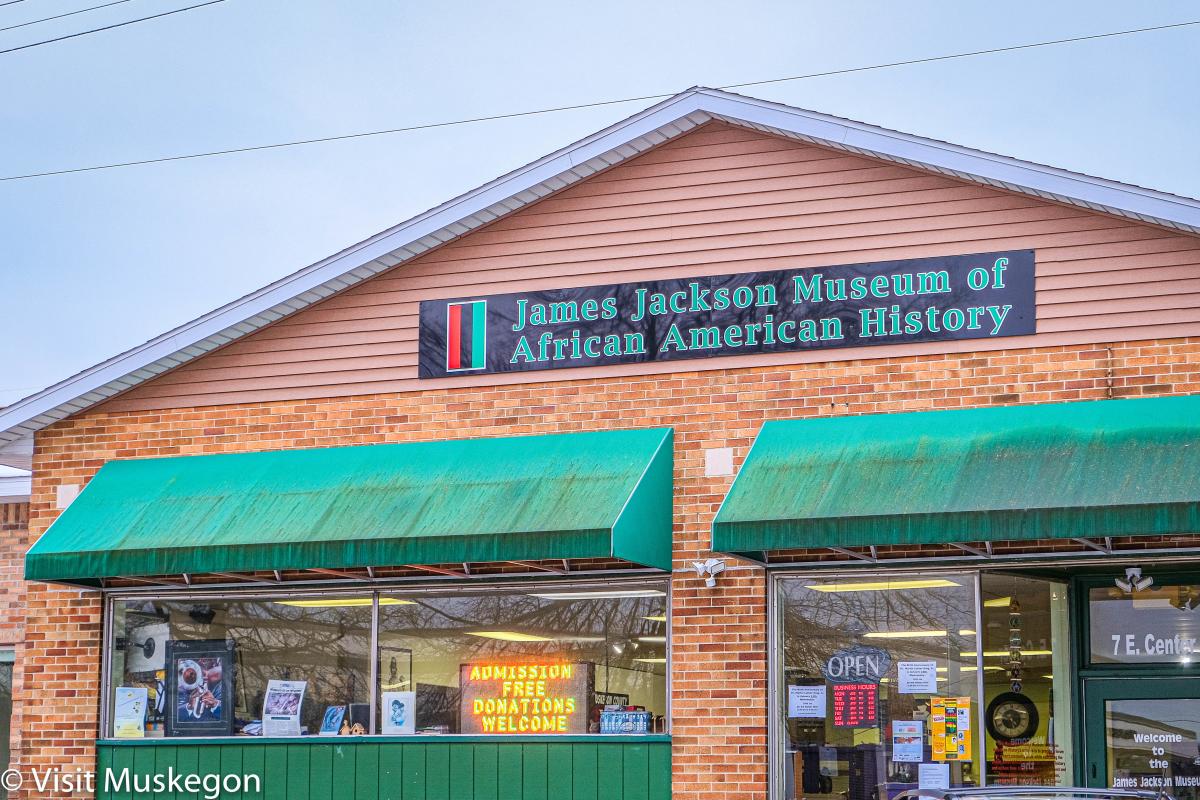 brick building with green awnings over window. sign beneath roof says James Jackson Museum of African American History