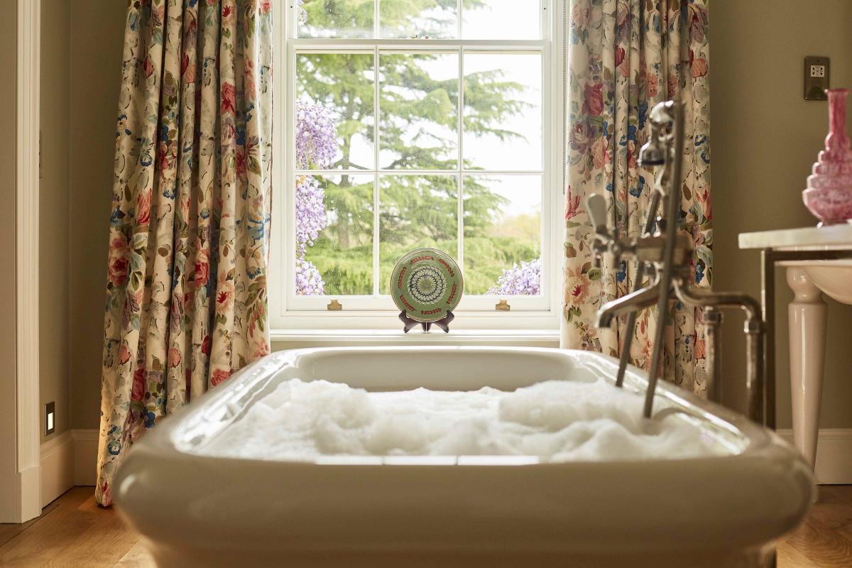 Bath by the window in bedroom at Lime Wood in the New Forest