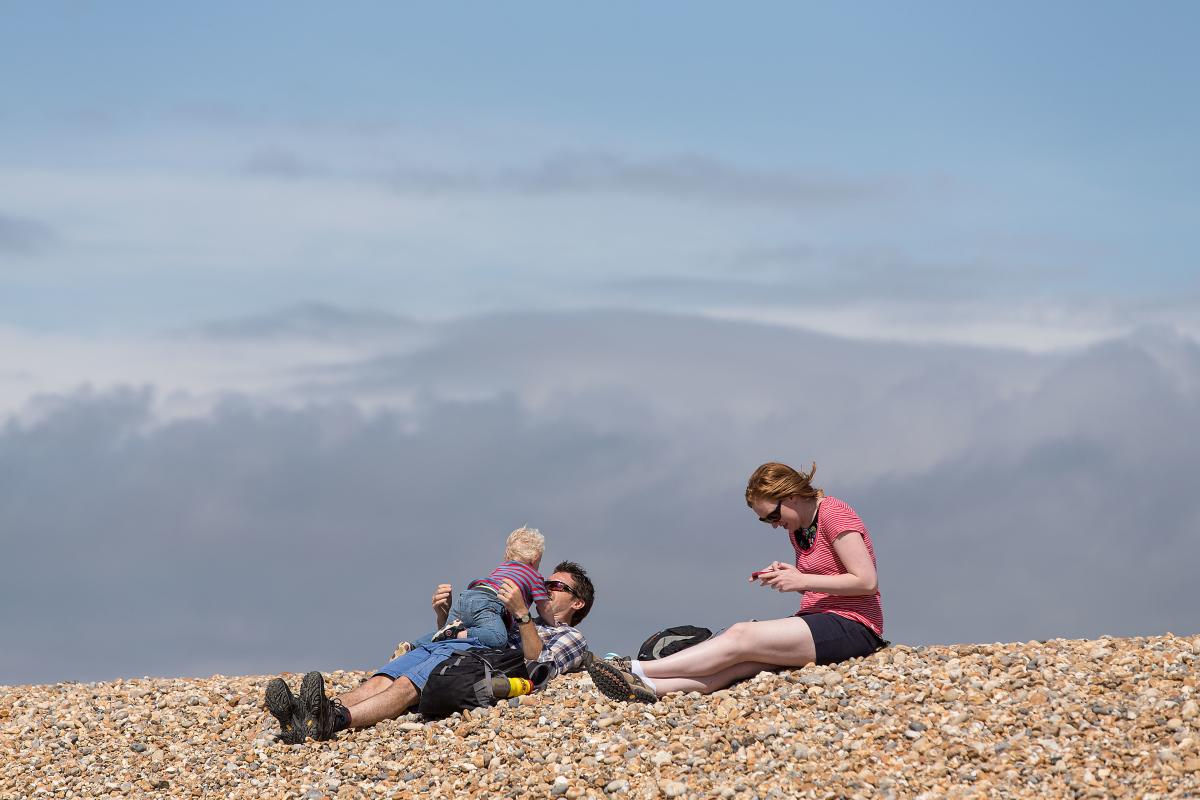 Family sitting on the shore at beach in the New Forest