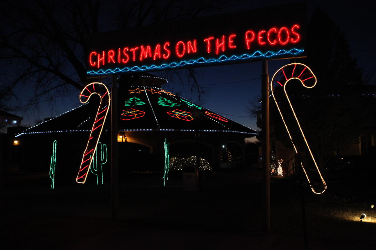 Colorful neon lights decorate a small yurt with Christmas imagery, a suspended neon sign reads Christmas on the Pecos.
