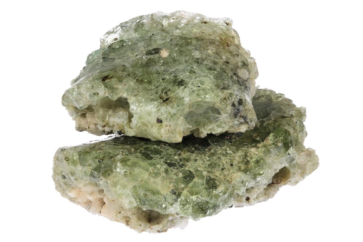 Two irregular pieces of grayish-green trinitite, the glassy material formed during the 1945 Trinity atomic test.