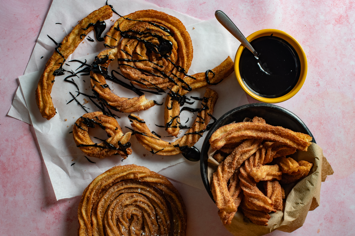 Crispy cinnamon-dusted churros served with caramel sauce.