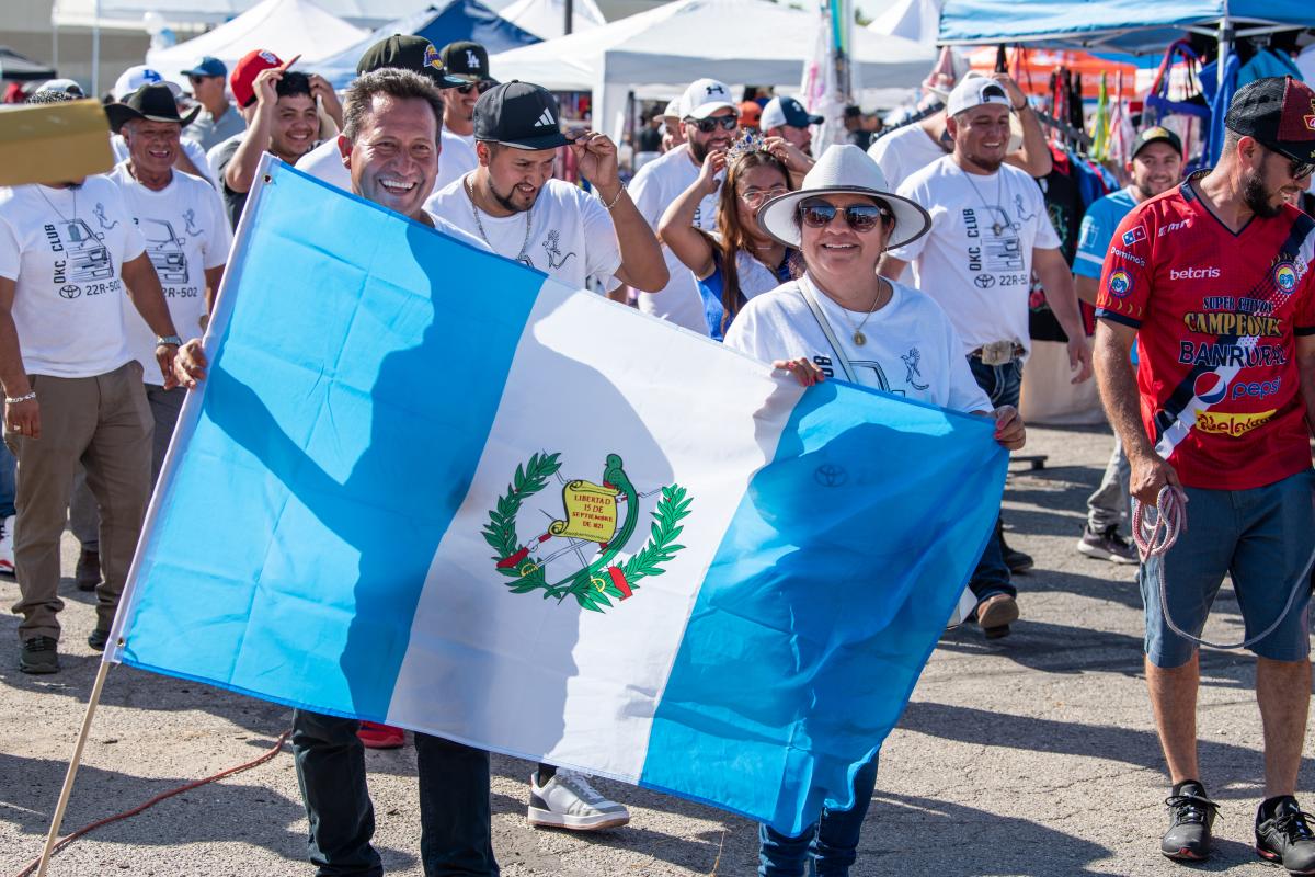 Man and woman holding the Guatemalan flag at Festival ChapÍn