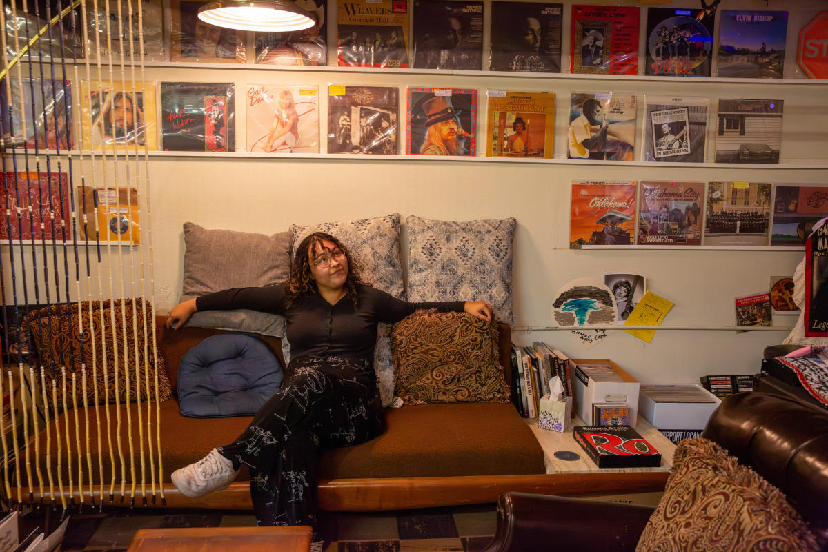 person sitting on couch with music records around them in Alley Records in Oklahoma City